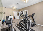 Thumbnail 28 of 30 - A home gym with a treadmill, elliptical trainer and a stationary bike.
