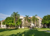 Thumbnail 16 of 24 - Exterior building view with grass at Banyan Pointe, Coconut Creek, FL 33073