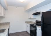 Thumbnail 12 of 23 - Kitchen with Black Appliances and Washer/Dryer Access at Aqua 2800, Oakland Park, Florida