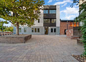 Thumbnail 49 of 81 - the front of a house with a brick patio and a tree