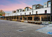 Thumbnail 46 of 81 - a row of buildings with balconies and a brick sidewalk
