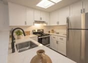 Thumbnail 2 of 38 - Kitchen with White Cabinets, Quartz Countertops, and Stainless Steel Appliances at THE ARLO, California, 95621