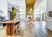 Thumbnail 11 of 12 - A modern kitchen with a wooden island and chairs at AGAVE APARTMENTS, CA 95757