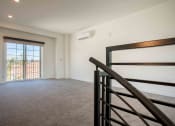 Thumbnail 18 of 41 - a bedroom with a staircase and a large window at THE ANGELINO, Sacramento
