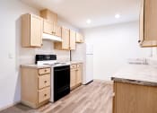 Thumbnail 5 of 24 - Kitchen with Wood-Style Flooring at Devonwood and First Place Apartments, Battle Ground, WA