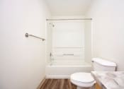 Thumbnail 15 of 24 - Bathroom with full size tub and plank flooring at Devonwood and First Place Apartments, Battle Ground Washington
