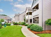 Thumbnail 22 of 24 - Building exteriors and lush landscaping at Devonwood and First Place Apartments, Battle Ground Washington