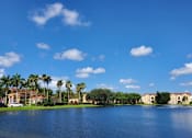Thumbnail 1 of 15 - Lake view with buildings at Bernwood Trace Apartments, Fort Myers, FL