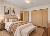 Thumbnail 15 of 30 - A bedroom with a large bed and two nightstands.