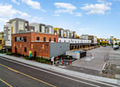 Thumbnail 60 of 81 - a red brick building with a lot of other buildings behind it