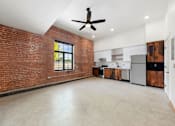 Thumbnail 17 of 81 - an empty living room with a brick wall and a ceiling fan