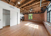 Thumbnail 28 of 81 - an open living room with exposed brick and wood ceilings and a large window