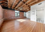 Thumbnail 34 of 81 - an empty living room with exposed brick and wood floors