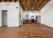 Thumbnail 29 of 81 - a large empty room with white walls and wood floors