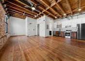 Thumbnail 31 of 81 - a large living room with wood floors and a kitchen