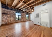 Thumbnail 33 of 81 - an open living room with exposed brick walls and wood floors