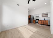 Thumbnail 40 of 81 - a living room with white walls and a kitchen