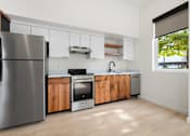 Thumbnail 22 of 81 - a kitchen with white cabinets and stainless steel appliances and a window