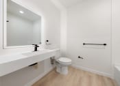 Thumbnail 16 of 81 - Apartments In Upper Land Park, Sacramento, CA For Rent - Market Club At The Mill - Full Bathroom With Shower, Wood-Style Flooring, White-topped Vanity, And Dark Wood Cabinetry