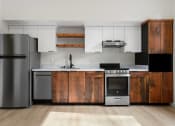 Thumbnail 3 of 81 - Upper Land Park Sacramento CA Apartments for Rent - Market Club at The Mill - Kitchen with Silver Appliances,Wood-Style and White Cabinetry, White Marble-Style Counter, Plank Flooring, and Black Hardware