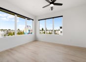 Thumbnail 9 of 81 - an empty living room with large windows and a ceiling fan
