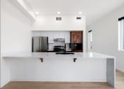 Thumbnail 4 of 81 - a white kitchen with a large island and a black stove and refrigerator