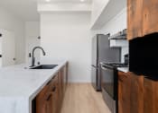 Thumbnail 14 of 81 - a kitchen with marble counter tops and wooden cabinets and a stainless steel refrigerator