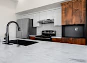 Thumbnail 21 of 81 - a kitchen with marble counter tops and black appliances