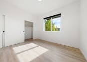 Thumbnail 10 of 81 - 1 BR Apartments in Upper Land Park Sacramento CA - Market Club at The Mill - Unfurnished Bedroom Space with Light Plank-Style Flooring, Window, and Closet
