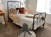 Thumbnail 28 of 34 - a bedroom with a bed and a rocking chair in front of it at FARM BY VINTAGE, MILL CREEK, WA 98012