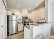 Thumbnail 5 of 63 - Kitchen with Granite-Style Countertops, Stainless-Steel Appliances, and Bar at BELLA SONOMA, Fife 
