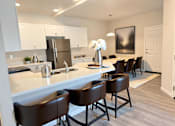 Thumbnail 4 of 10 - A kitchen with brown chairs and a white counter at Cottages at Laguna, California