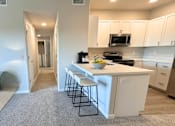 Thumbnail 7 of 10 - A kitchen with white cabinets and a white island with a bowl of fruit on it at Laguna, California