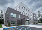 Thumbnail 1 of 8 - grey building near parking at TRILLIUM LANDING, JUNEAU, AK