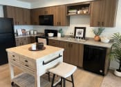 Thumbnail 31 of 34 - a small kitchen with a small island in the middle at FARM BY VINTAGE, MILL CREEK Washington