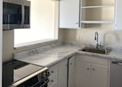 Thumbnail 13 of 19 - A small kitchen with a stove and a sink.at Via Casitas, Greenbrae California