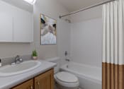 Thumbnail 20 of 20 - A bathroom with a white sink, toilet, and bathtub at Lake Washington Apartments, Seattle, WA 98118
