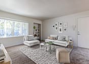 Thumbnail 16 of 20 - A living room with a white couch, a green coffee table, and a rug at Lake Washington Apartments, Seattle, WA