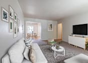 Thumbnail 17 of 20 - A living room with a white couch, a coffee table, and a television at Lake Washington Apartments, Washington 98118