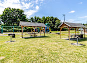 Thumbnail 6 of 20 - A park with picnic tables and pavilions at Lake Washington Apartments, Seattle Washington