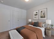 Thumbnail 19 of 20 - A bedroom with a bed, two lamps, and two framed pictures on the wall at Lake Washington Apartments, 98118