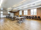 Thumbnail 7 of 20 - A large room with tables and chairs and a kitchen area.at Lake Washington Apartments, Seattle