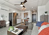 Thumbnail 12 of 20 - A modern kitchen with a refrigerator, a dining table with chairs, and a living area with a couch and a coffee table at LOFT 205 Apartments, Nevada, 89501