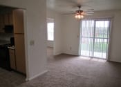 Thumbnail 9 of 28 - A room with a ceiling fan and sliding glass doors.