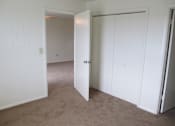 Thumbnail 6 of 28 - A white room with a carpeted floor and a white door.