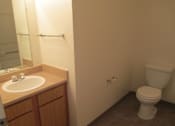 Thumbnail 12 of 28 - A white toilet sits in a bathroom next to a sink.