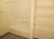 Thumbnail 11 of 28 - A white walk-in closet with shelves and a bench.