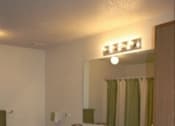 Thumbnail 21 of 28 - A bathroom with a toilet, sink, and mirror.
