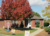 Thumbnail 5 of 28 - A house with a sign that says "NOW LEASING" in front of it.