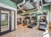 Thumbnail 15 of 33 - a gym with weights and cardio machines and a glass door